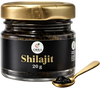 Jar of Shilajit with a gold spoon on a white background